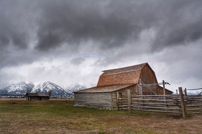 Built structure on snow covered field against sky