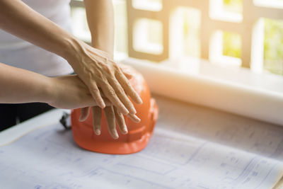 Cropped image of architects stacking hands at office