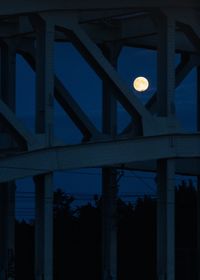 Low angle view of illuminated bridge against sky at night