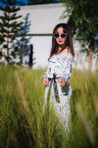 Portrait of woman wearing sunglasses on field