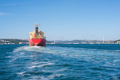 Ship sailing in sea against clear blue sky