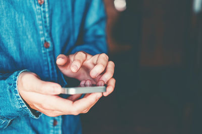 Midsection of man using mobile phone