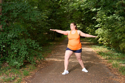 Full length of young woman exercising in park