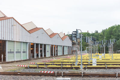 Houses by railroad tracks against sky