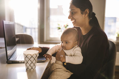 Mother with baby working from home