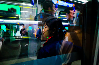 Portrait of woman looking through window at store