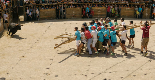 High angle view of people bullfighting on field