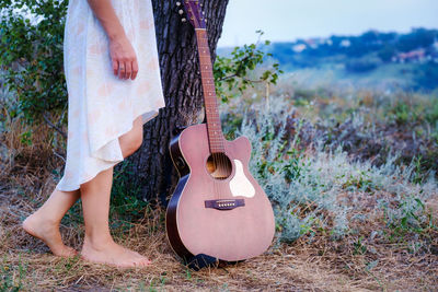 Midsection of woman playing guitar