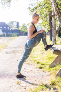 Side view of young woman exercising at park