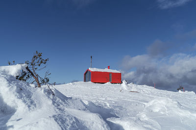 Snow covered landscape against blue sky