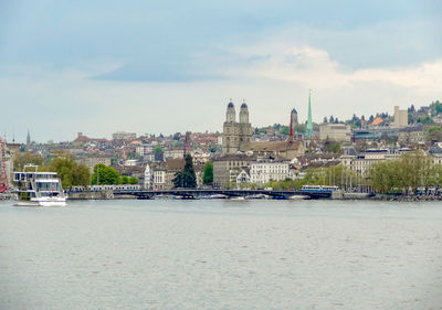 View of buildings at waterfront against cloudy sky