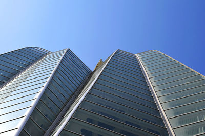 Low angle view of modern buildings against clear blue sky