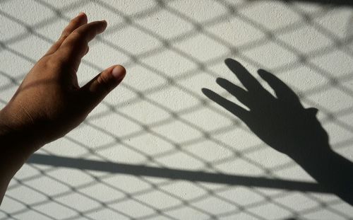 Shadow of person hand on tiled floor