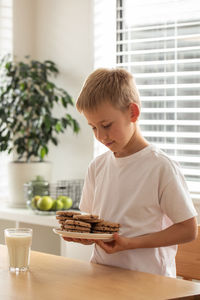 Side view of boy eating food at home