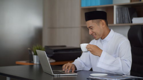 Young woman using laptop at office