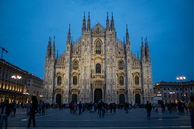 People in front of milan cathedral against clear sky at night