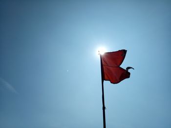 Low angle view of flag against clear blue sky