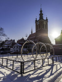 Church by building against clear sky during winter