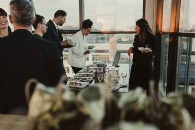 Smiling business people having during office party