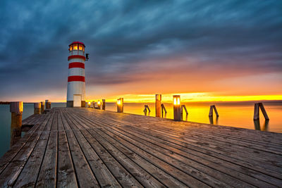 Pier over sea against sky during sunset