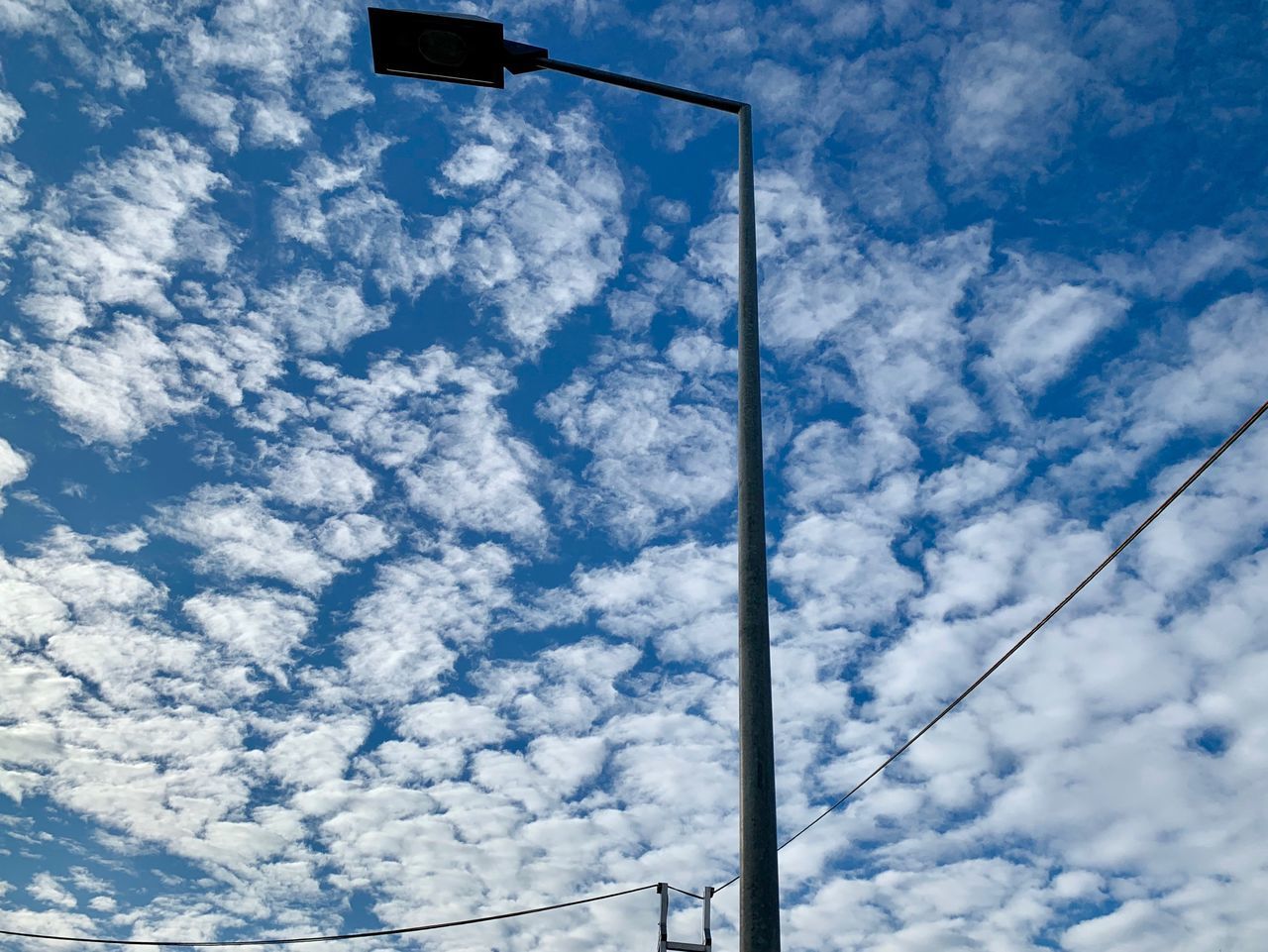 LOW ANGLE VIEW OF STREET LIGHTS AGAINST CLOUDY SKY