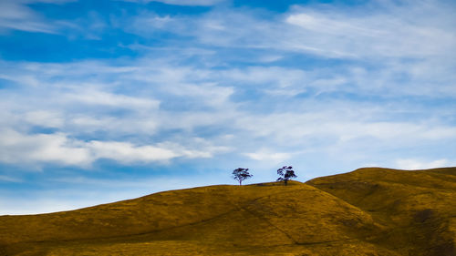 Low angle view of landscape against cloudy sky