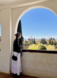 Rear view of woman standing against built structures