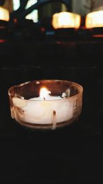 Close-up of lit candle in dark room