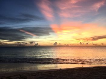 Scenic view of sea against dramatic sky during sunset