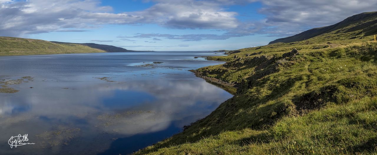 water, sky, tranquil scene, tranquility, scenics, beauty in nature, cloud - sky, mountain, nature, cloud, lake, cloudy, reflection, idyllic, sea, non-urban scene, landscape, outdoors, calm, day