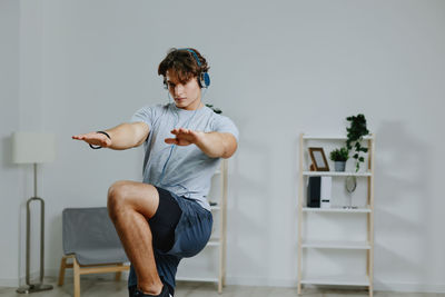 Full length of boy sitting on sofa at home