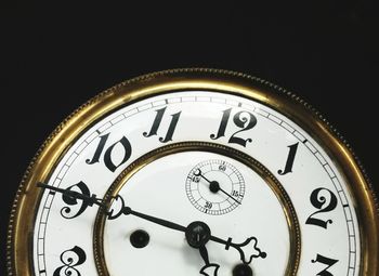 Close-up of clock over black background