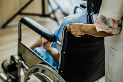 Midsection of man using mobile phone while sitting on seat