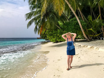 Full length of young woman standing on beach