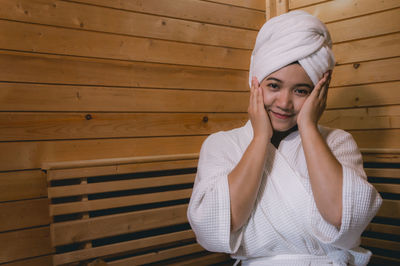 Portrait of woman hair wrapped in towel while sitting at spa