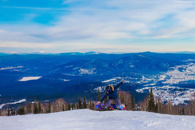 Full length of man snowboarding on snow covered mountain