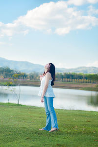 Full length of woman standing on field against sky