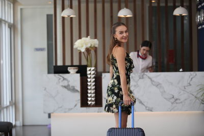 Portrait of smiling young woman standing at home