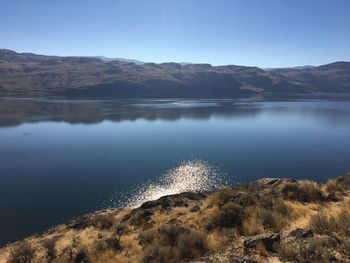 Scenic view of lake and mountains against clear sky