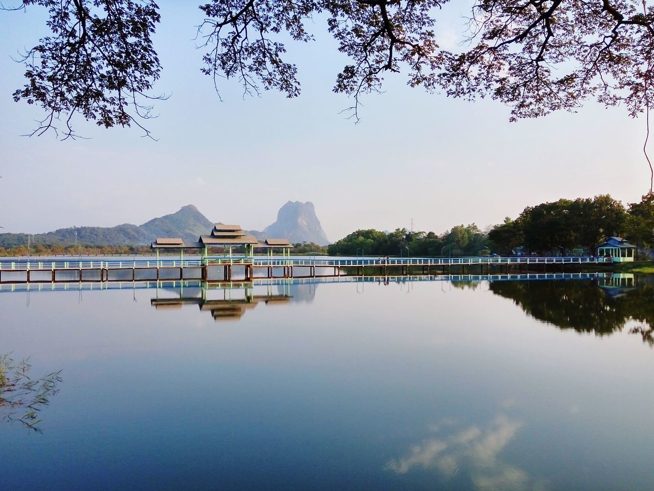 water, lake, tree, reflection, built structure, clear sky, architecture, waterfront, tranquility, tranquil scene, river, building exterior, nature, sky, standing water, day, scenics, copy space, beauty in nature, outdoors