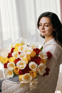 Portrait of young woman holding bouquet