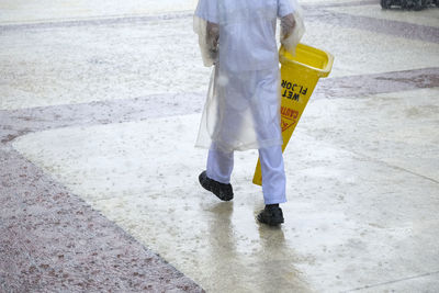 Low section of person standing on wet street