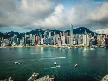 View of buildings in city against cloudy sky