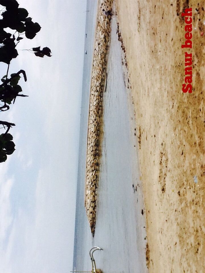 beach, sky, sand, text, shore, nature, sea, tranquility, day, communication, western script, outdoors, water, tranquil scene, leisure activity, scenics, cloud - sky, mountain, lifestyles