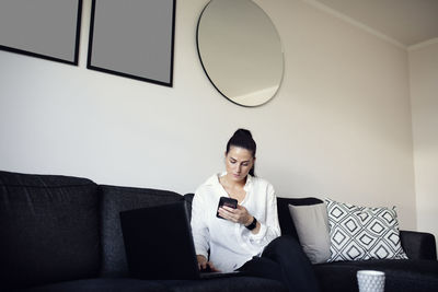 Woman on sofa using cell phone