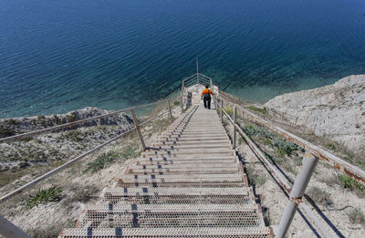High angle view of people on staircase by sea
