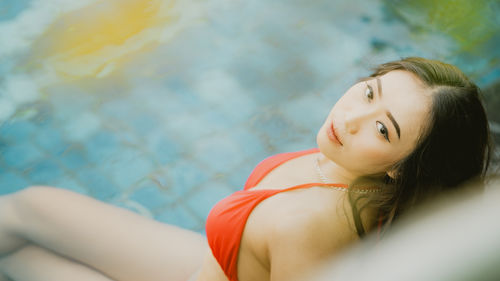 Side view of young woman sitting in swimming pool