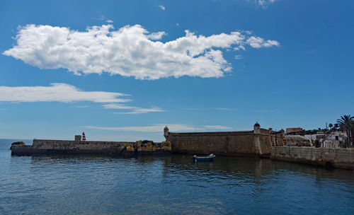 Scenic view of sea by building against sky