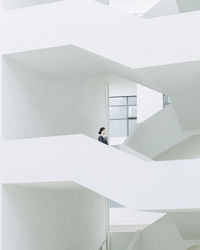 Low angle view of young woman standing in building corridor