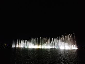 Panoramic shot of illuminated water against clear sky at night